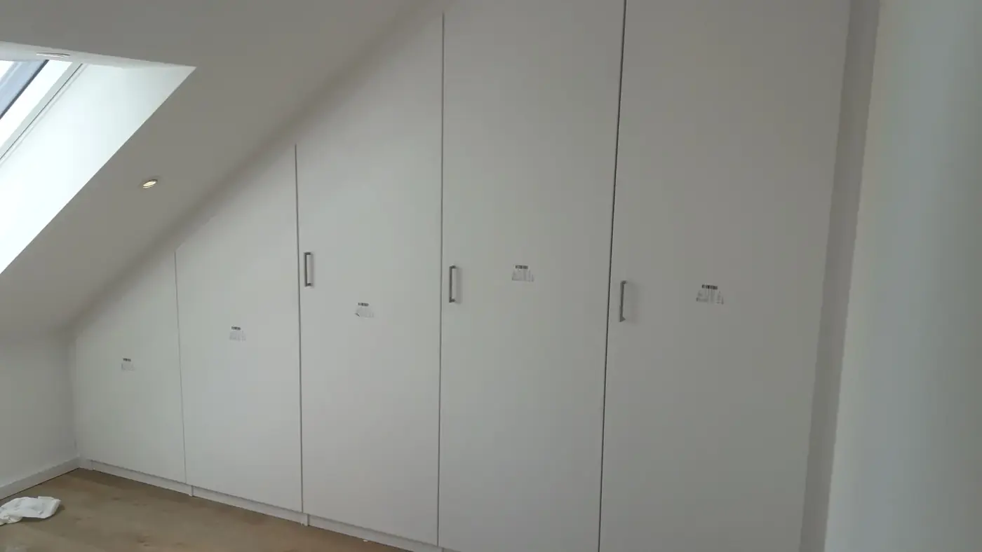 Passgenauer weißer Einbauschrank unter einer Dachschräge