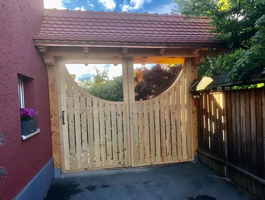 Von Innenausbau Miny gefertigtes Holztor mit überdachter Konstruktion